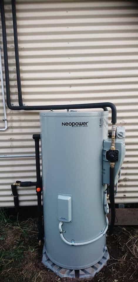 Neopower solar hot water tank installed beside a corrugated iron wall