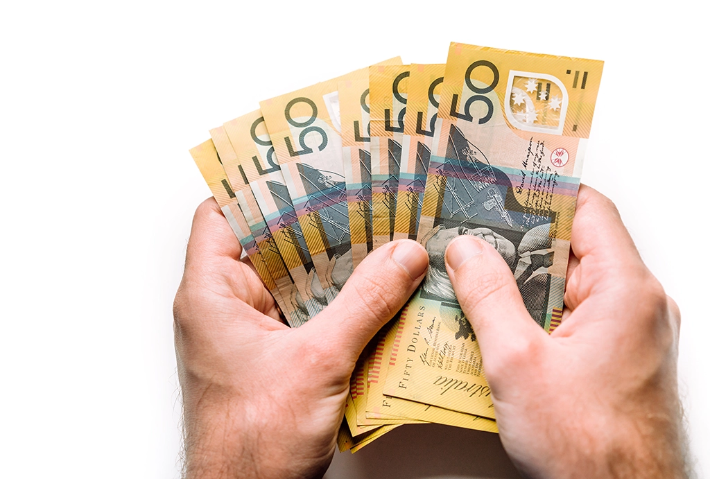 Hands holding a fan of Australian fifty dollar notes