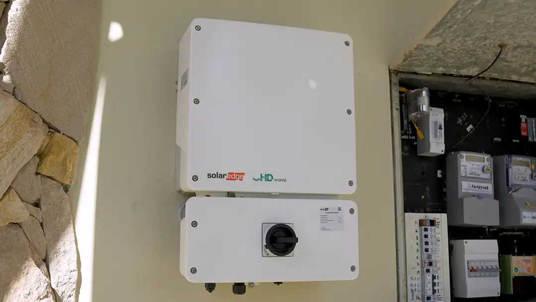 A SolarEdge inverter mounted beside a meter box
